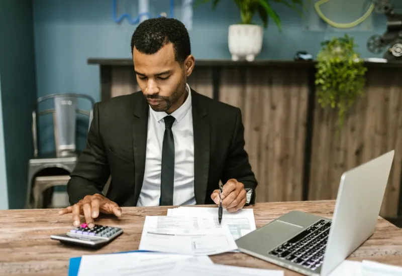 accountant-using-calculator-at-desk